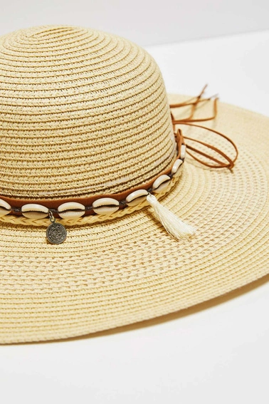 Kapelusz słomkowy z szerokim rondem i ozdobiony muszelkami piaskowy