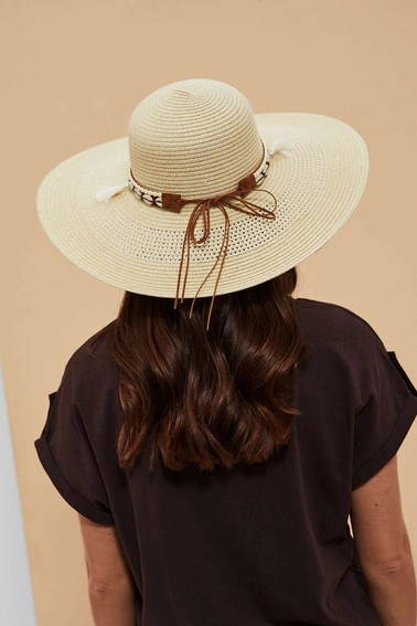 Kapelusz słomkowy z szerokim rondem i ozdobiony muszelkami piaskowy