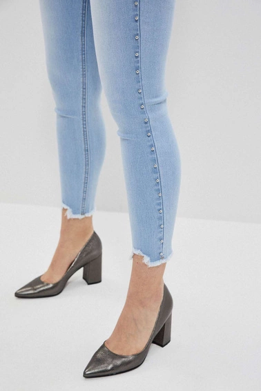 Jeansy medium waist z postrzępionymi nogawkami błękitne